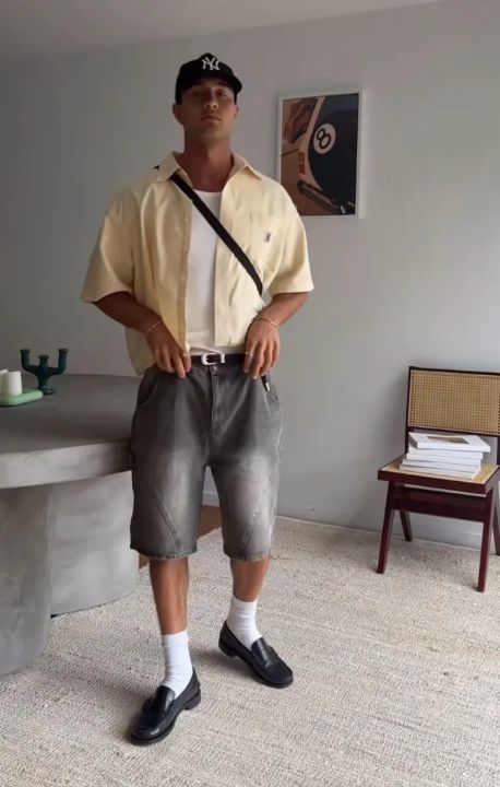 Outfit: Black baseball cap, Light yellow short-sleeve button-up shirt, White tank top, Black crossbody bag